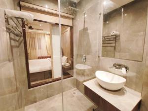 uma casa de banho com um lavatório e um chuveiro em Hotel CJ International em Amritsar