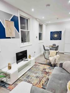 a living room with a couch and a tv at Coastal Luxury Home in Margate in Margate