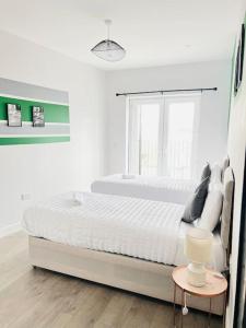 a white bedroom with a bed and a window at Coastal Luxury Home in Margate in Margate