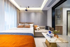 un dormitorio con una cama y un sofá en 岗厦汇花园行政公寓酒店-深圳福田会展中心岗厦地铁站店, en Shenzhen