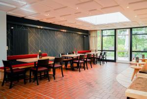 a dining room with tables and chairs and windows at Hotel Lindenhof in Bielefeld