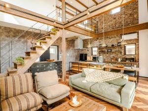 ein Wohnzimmer mit einem Sofa und einer Treppe in der Unterkunft AMAZING LIFESTYLE GLAMPING HOTEL - Vacation STAY 48572v in Nagahama