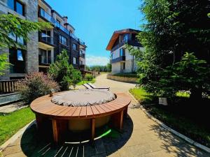 a circular wooden table in the middle of a courtyard at Chamkoria Chalets in Borovets