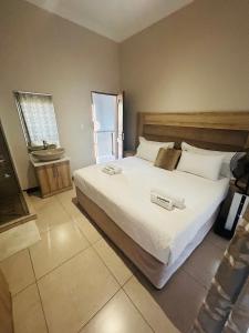 Un dormitorio con una gran cama blanca con una báscula. en Bluewave Lifestyle Villa, en Hartbeespoort