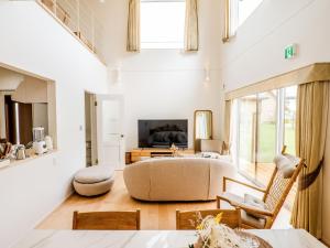 ein Wohnzimmer mit einem Sofa und einem TV in der Unterkunft AMAZING LIFESTYLE GLAMPING HOTEL - Vacation STAY 43987v in Nagahama