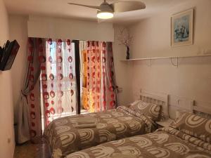 um quarto com 2 camas e uma janela em VINTAGE BENIDORM em Benidorm