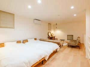 ein Schlafzimmer mit einem großen weißen Bett und einem Stuhl in der Unterkunft AMAZING LIFESTYLE GLAMPING HOTEL - Vacation STAY 43987v in Nagahama