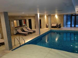 a swimming pool in a hotel with chairs and tables at Chamkoria Chalets in Borovets