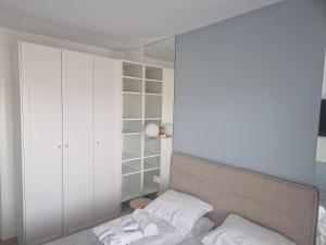 um quarto com uma cama com almofadas brancas e um espelho em Apartament Kołobrzeg Aqua Polanki em Kolobrzeg