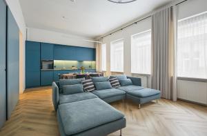 ein Wohnzimmer mit einem blauen Sofa und einem Tisch in der Unterkunft Kurpiai Old Town, 3BD in Kaunas