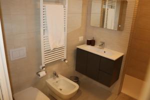 een badkamer met een wastafel, een toilet en een spiegel bij Negrar monolocale a 700m da ospedale in Negrar