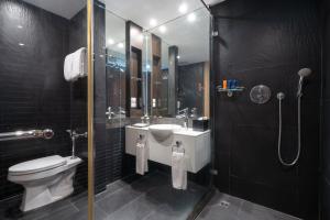 a bathroom with a toilet and a sink and a shower at VIC 3 Bangkok Hotel in Bangkok