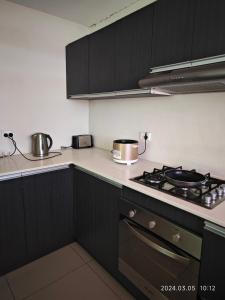 a kitchen with black cabinets and a stove with pots and pans at 1 Pacific FairPrice in Nadi +5 photos