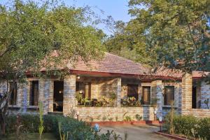 a brick house with a garden in front of it at Vijay Vilas Heritage Resort in Lāeja