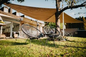 two chairs and a table in a yard with a tent at Hirschenwirt in Eichstätt