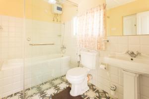 a bathroom with a toilet and a tub and a sink at Rockbourne Bungalow in Kandy