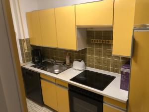 a small kitchen with yellow cabinets and a sink at Haus Diepholz in Diepholz +4 photos