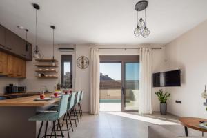 a kitchen and living room with a table and chairs at New Modern Villas with Private Pools and Walking distance to Beach in Panormos Rethymno