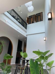 a staircase in a building with chairs and plants at HAKKA Wellness Residence in Samut Songkhram