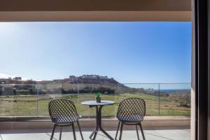 a table and two chairs in front of a window at New Modern Villas with Private Pools and Walking distance to Beach in Panormos Rethymno