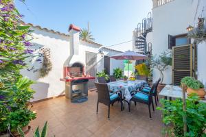 un patio con mesa, sillas y chimenea en Casa Caty, en Sa Ràpita