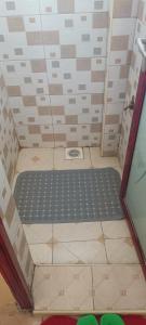 a shower with a black shower mat in a bathroom at Serene Studios Kamakis Eastern bypass in Ruiru
