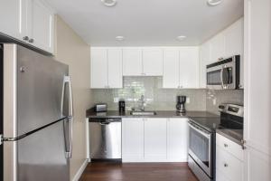 a kitchen with white cabinets and a stainless steel refrigerator at La Jolla 1br w gym wd pool nr bars shops SAN-44 in San Diego
