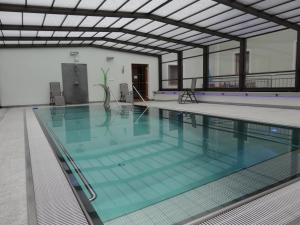 ein Pool mit blauem Wasser in einem Gebäude in der Unterkunft Business-Hotel Stockinger in Linz