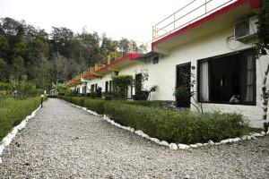 a building with a gravel road in front of it at Corbett Tiger Retreat in Rāmnagar