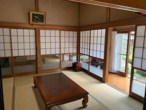 a room with a table in a room with windows at Glamp House HANANOMORI - Vacation STAY 12585 in Yotsukaidō