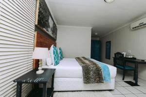 una camera con letto e tavolo con lampada di Madeline Grove Bed & Breakfast a Durban