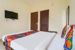 a bedroom with a bed with a colorful blanket at FabExpress Vangal Nest in Pīlamedu