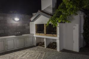 a kitchen with a counter with a fireplace in it at Quinta das Rosas Villas in Ribeira Grande