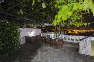 a patio with chairs and a table with a view of the city at Quinta das Rosas Villas in Ribeira Grande