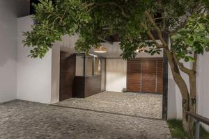 a house with wooden doors and a tree at Quinta das Rosas Villas in Ribeira Grande