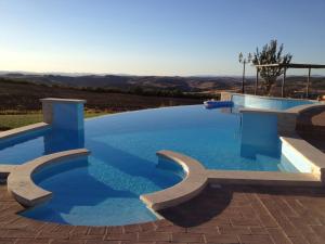 a large swimming pool with blue water at Agriturismo Il Macchione in Pienza