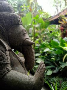 Une statue d'un éléphant avec son tronc en haut dans l'établissement Tanah Semujan Ubud, à Ubud