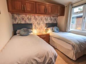 - 2 lits dans une chambre avec armoires et fenêtres dans l'établissement Hill Top Lodge, à Windermere