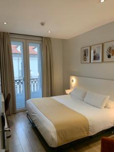 a bedroom with a large bed and a balcony at Hostal Sol Square Madrid in Madrid