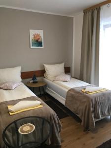 a room with two beds and a table and a window at Tannenhof in Semmering