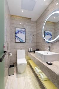 a bathroom with a white sink and a mirror at Yzhi Hotel - West Sports Road Metro Station in Guangzhou