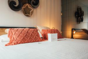 a bed with orange pillows and a sign on it at Cocoon by Jeanne - op 450m van B&B Jeanne in Nieuwpoort