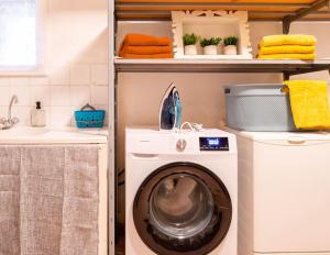 a laundry room with a washing machine and a sink at Le Charme de l'Orée des Lices in Carcassonne