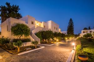 a large white building at night with lights at Palladium hotel in Marmari