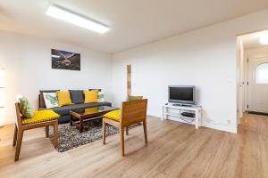 a living room with a couch and a tv at Sainte-Anne - Maison - Wifi - Parking in Sainte Anne d'Auray  +20 photos