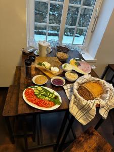 a wooden table with plates of food on it at Hotel Krasnoludki in Sosnówka