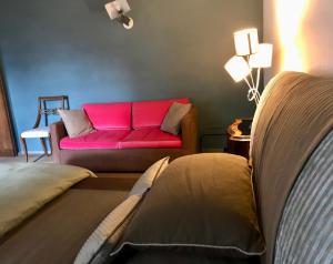 a living room with a red couch in a room at Bed&Breakfast La Madonnina in Marlia