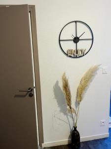 a clock on a wall next to a door at Le 2 - Grand studio avec coin repas Caen Port in Caen