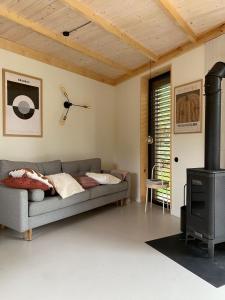 a living room with a couch and a stove at Sankakkei 2 - Lewy Brzeg Narwi in Burlaki