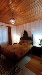 um quarto com uma cama grande e um tecto em madeira em Kanela Guest house em Machico